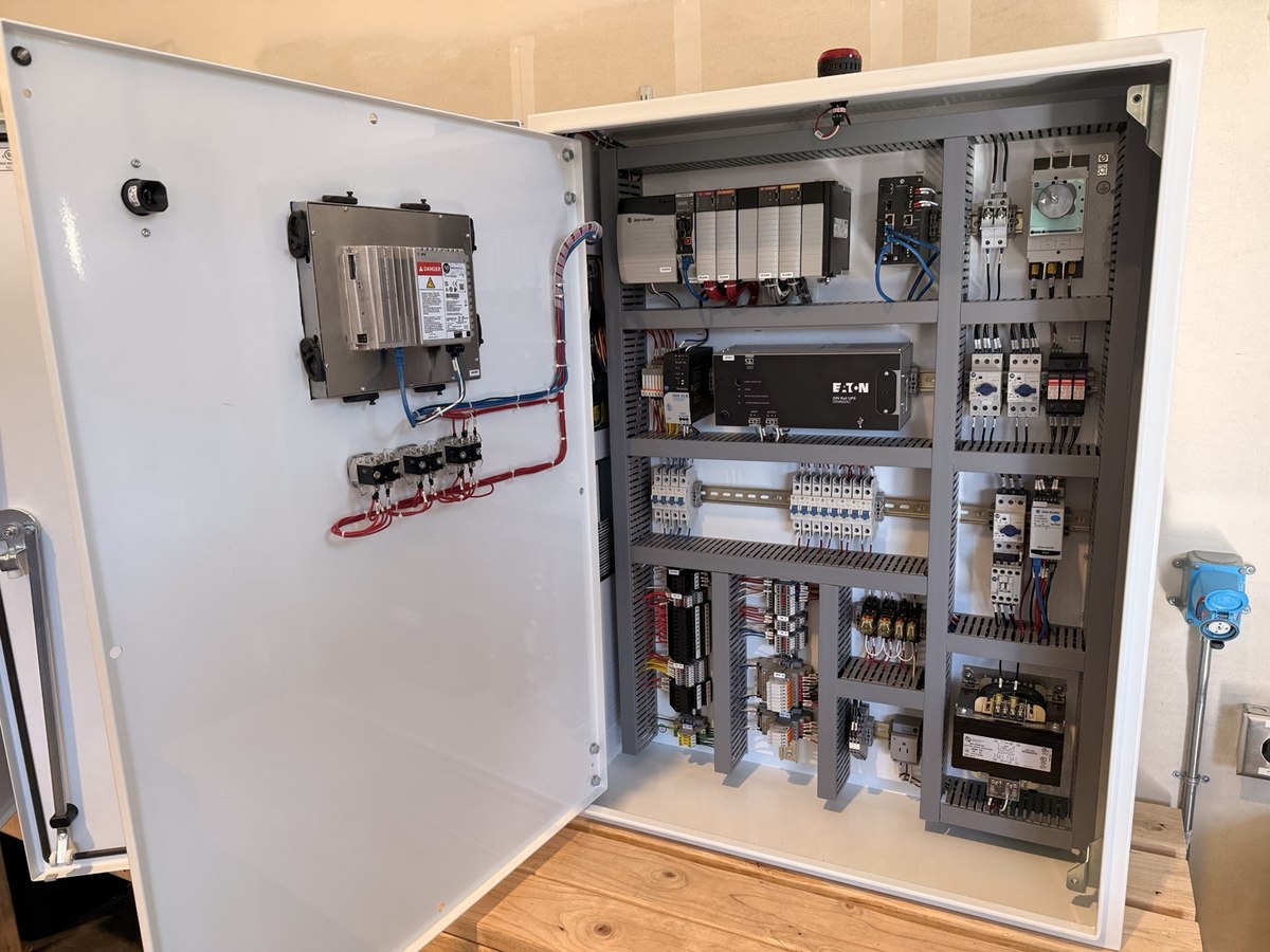 PLC control panel with Allen-Bradley PLC, door-mounted operator interface, Ethernet connections, backup power and motor controls.